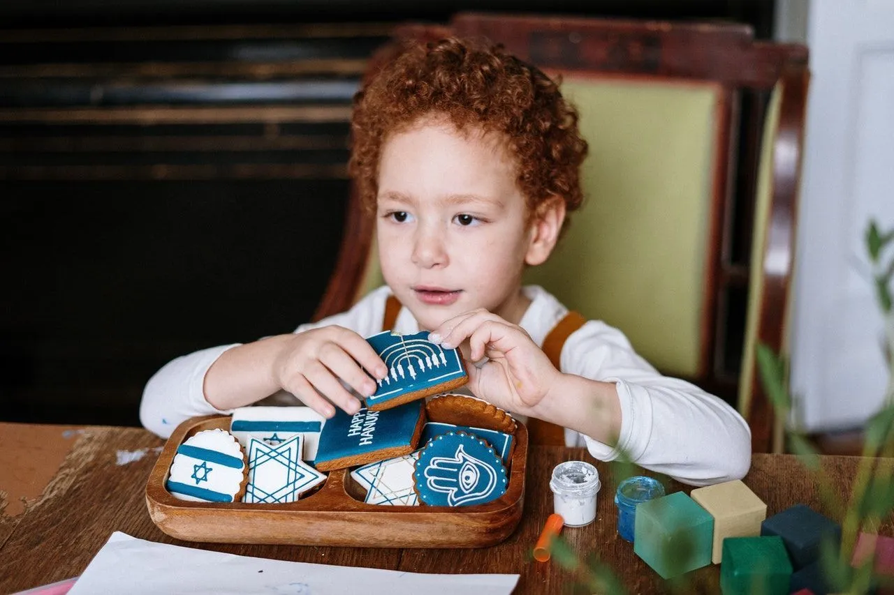 A jewish boy eating Hanukkah biscuits