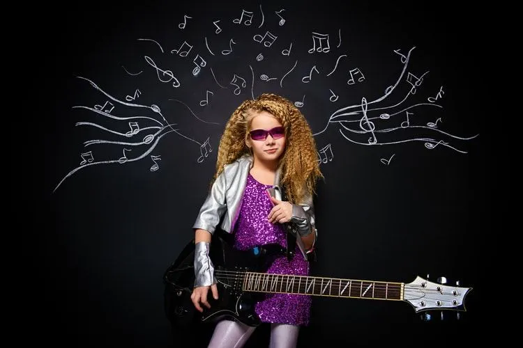 Little rock star singing with her electric guitar over musical background