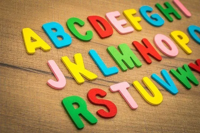 Colorful alphabets arranged on wooden table