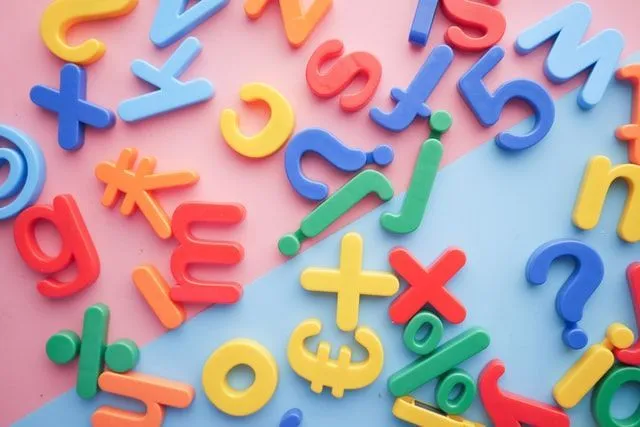 Colorful alphabets scattered on a pink and blue background