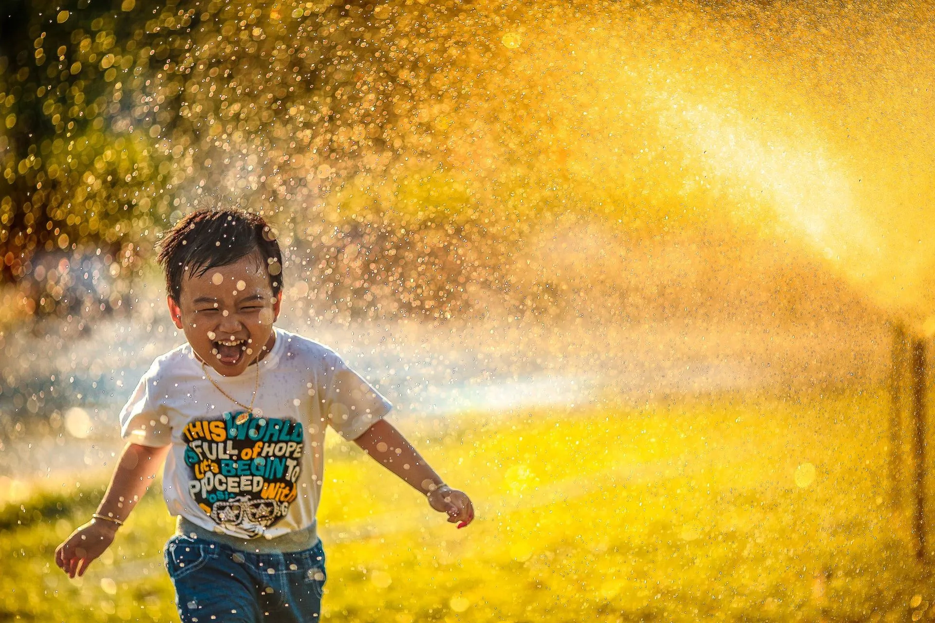 A little boy enjoying water sprinkler