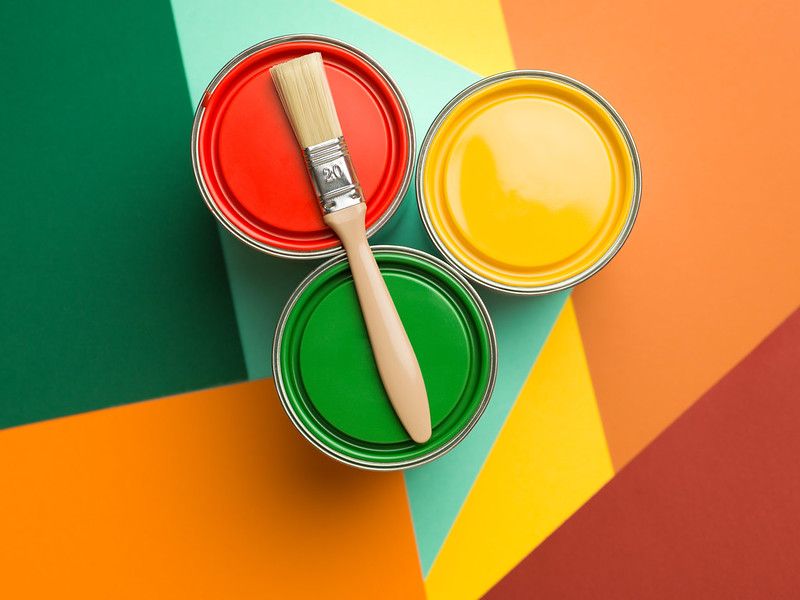 Cans filled with yellow, green and red paints.