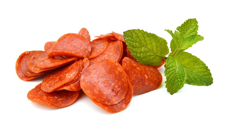 Slices of pepperoni on white background.