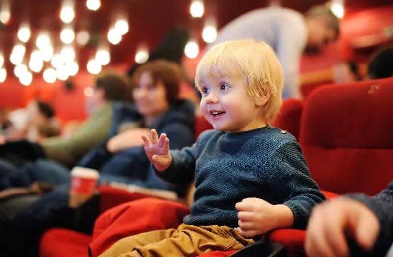 little boy at the theatre smiling