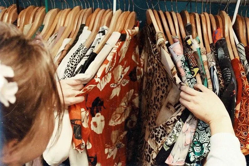little girl looking through vintage clothes