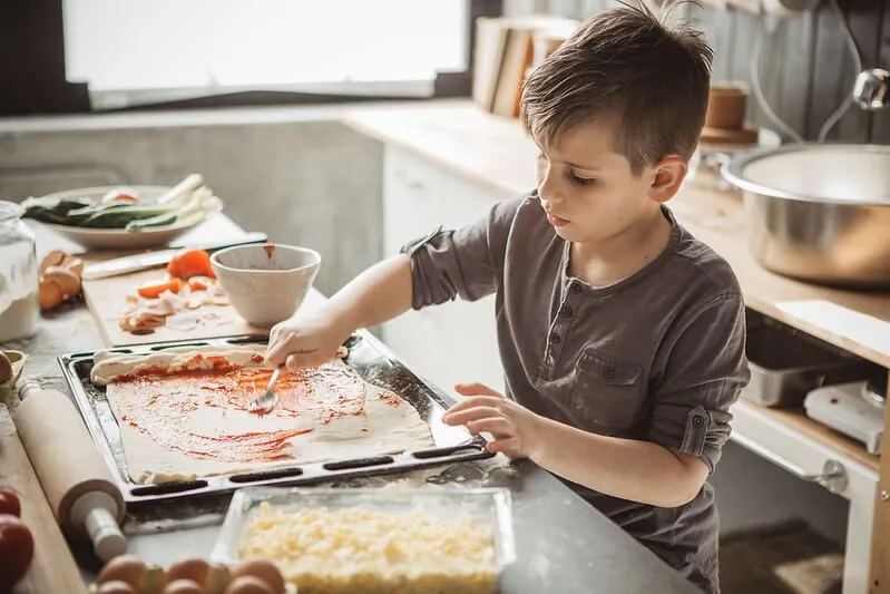 kid making pizza at home