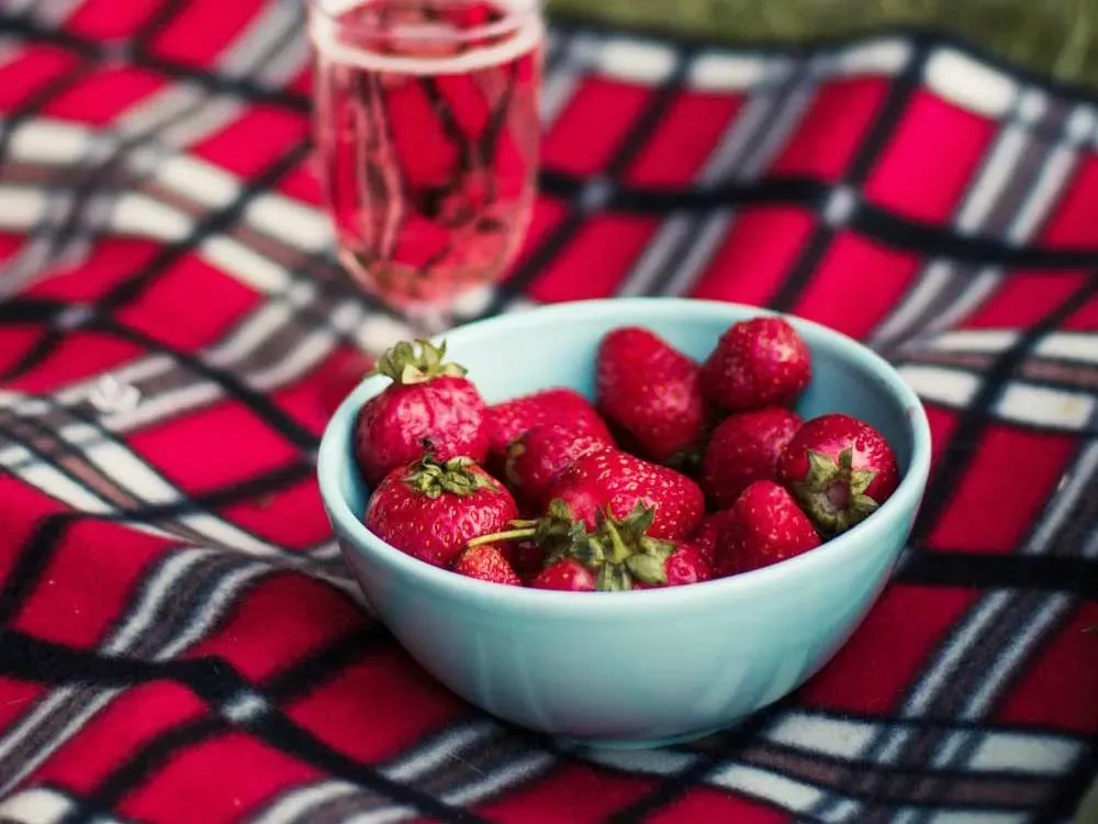 bowl of strawberries on picnic blanket