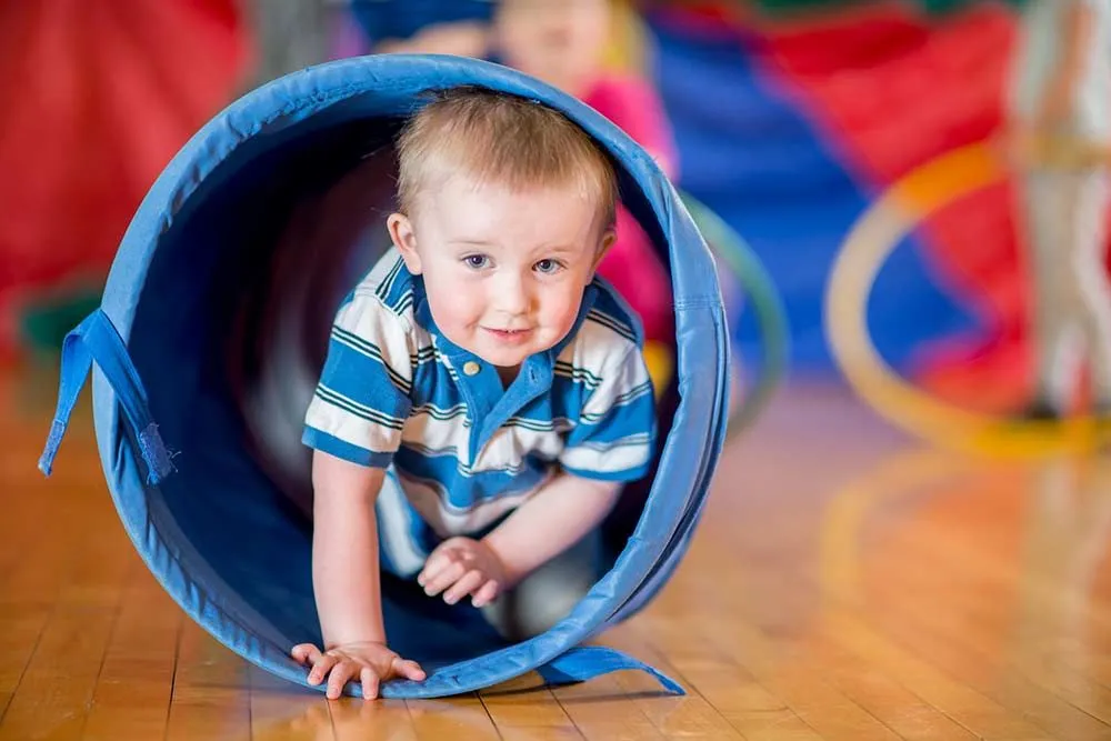 child in obstacle course tunnel