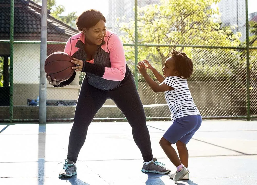 mother and daughter playing basketball