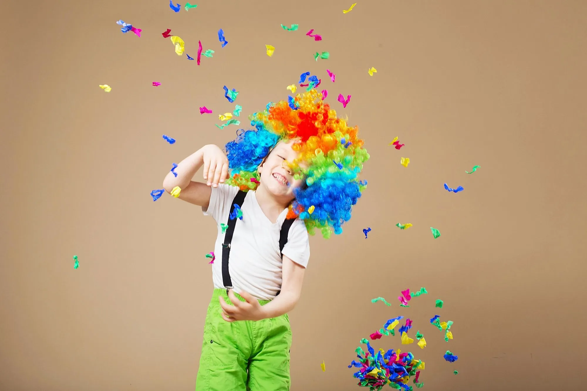 child dressed as a clown showered in confetti