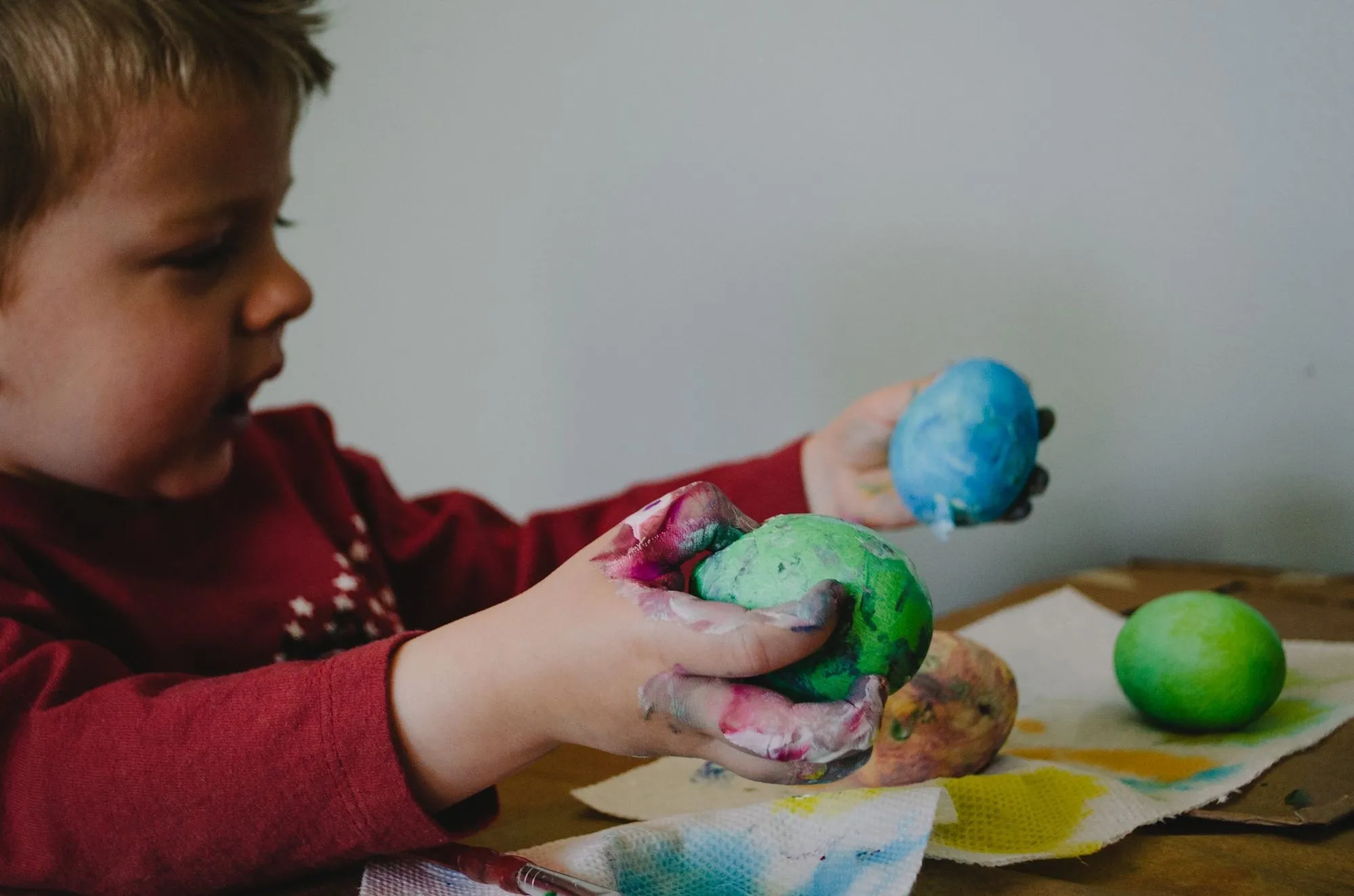 boy holding different coloured balls of dough