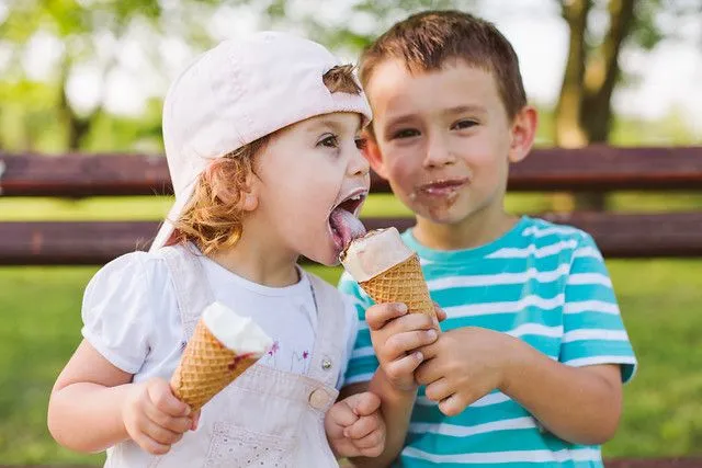 boy sharing ice cream with his little sister