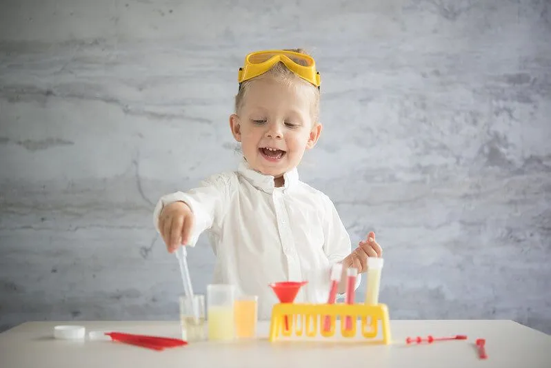Young child who loves STEM does a science experiment at home.