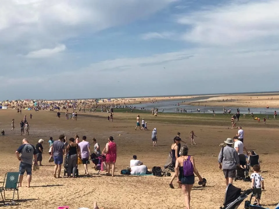 a busy norfolk beach on a hot summers day