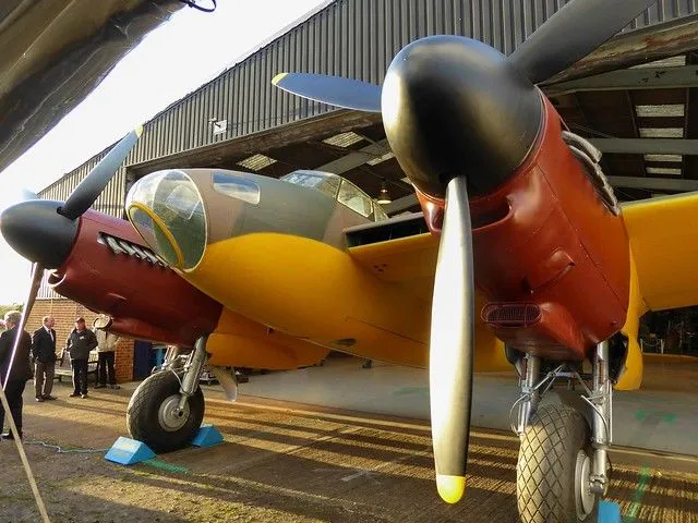 Yellow and red aircrafts outside a hangar at the De Havilland Aircraft Museum