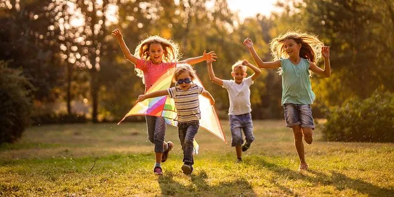 Happy kids running around in a field.