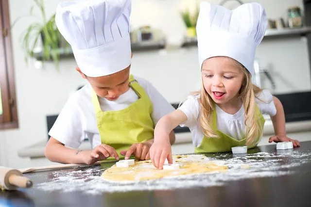 Two kids cooking some food and drink. Image