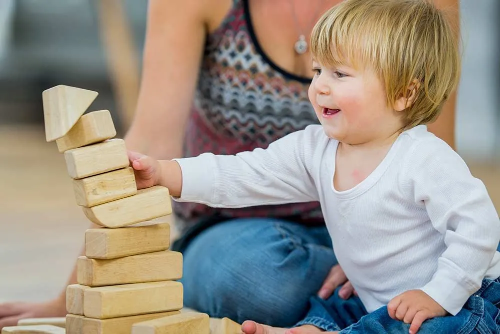young boy playing with building blocks
