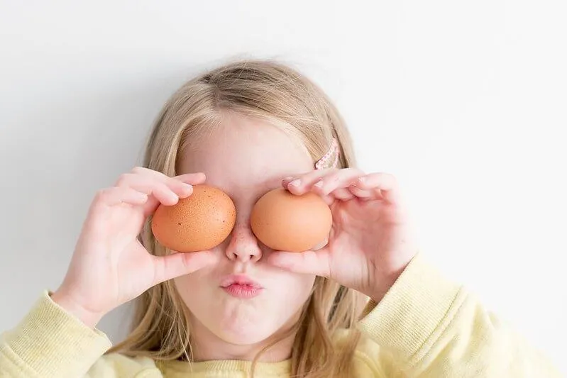 Child holding eggs that she will make into hollow eggs for the experiment