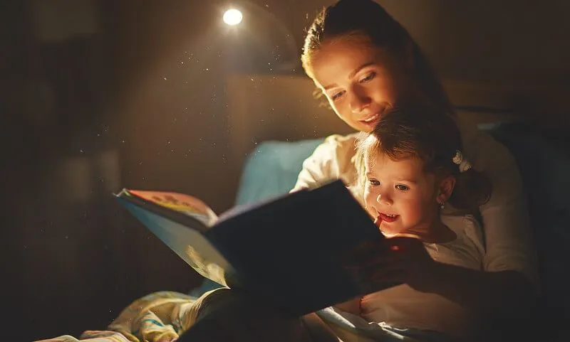 Mother and child reading bedtime stories before bed