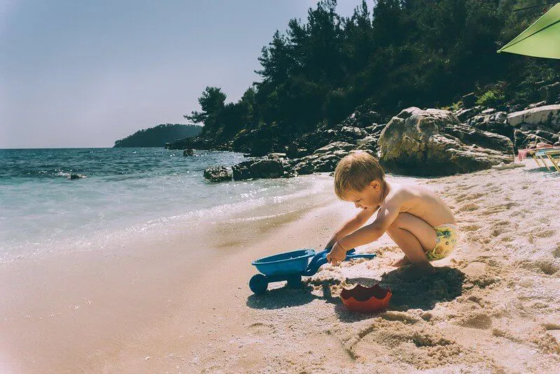 Baby playing on the beach on holiday after getting passport