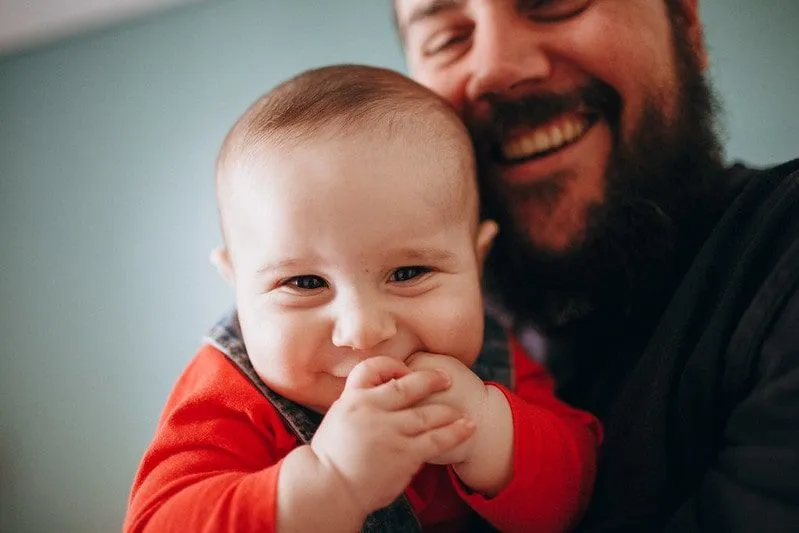 Baby Isaiah being held by his bearded father has a brilliant boys' name beginning with I.