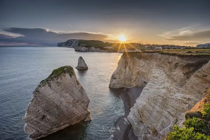 Sun setting over the cliffs of Freshwater Bay on the Isle of Wight, overlooking the sea.