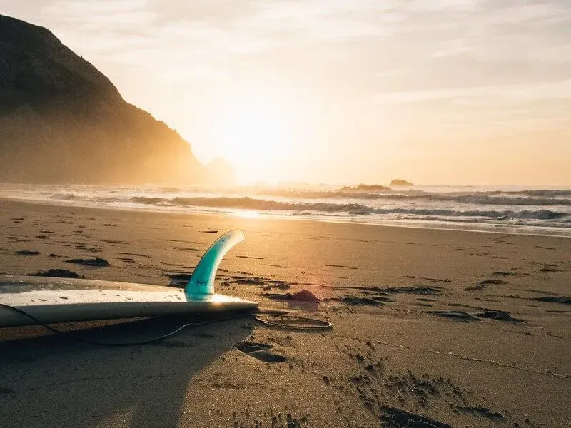 surfboard on a beach at sunset