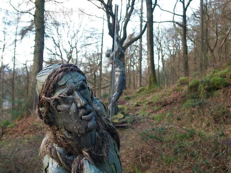 metallic sculpture of a person in a forest