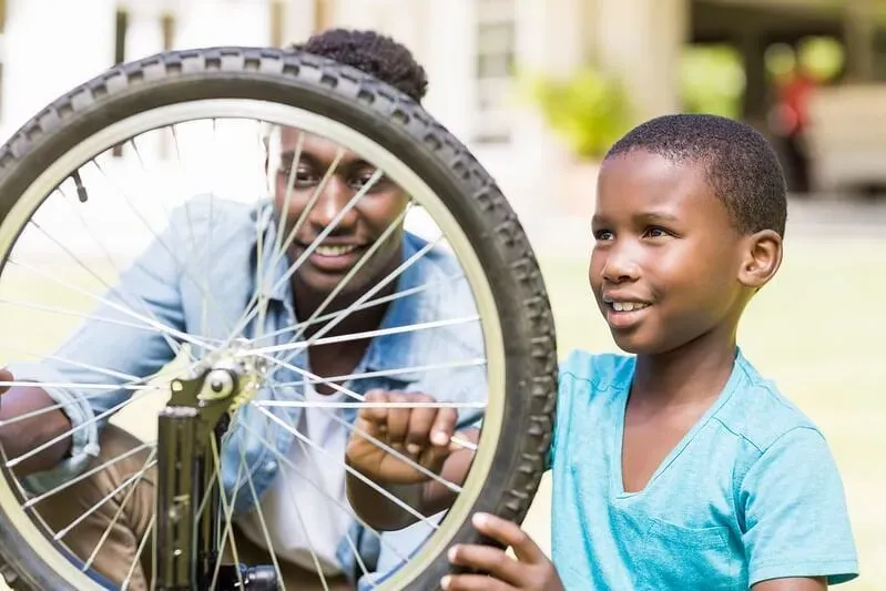 dad helping his son to fix a bike