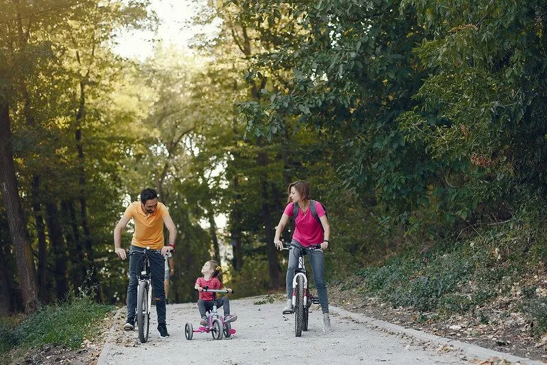 family riding their bikes in a forest