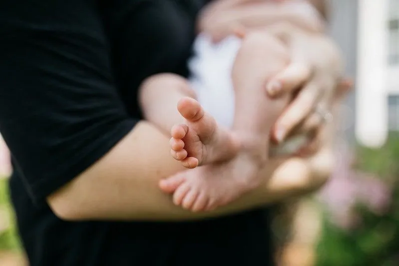 Baby's feet out while held by parent.