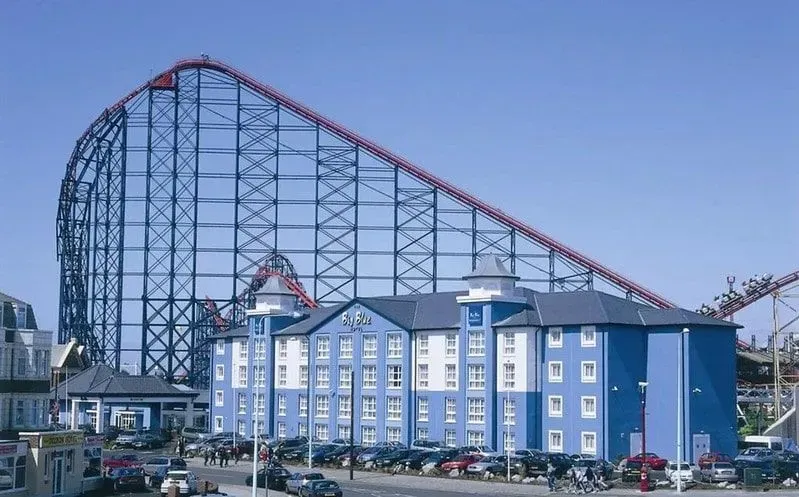 Front of the Big Blue Hotel, Blackpool, with a backdrop of the amusement park rollercoaster.