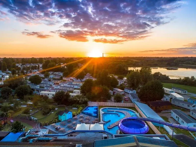 Birdseye view of the outdoor pool with waterslides at sunset.