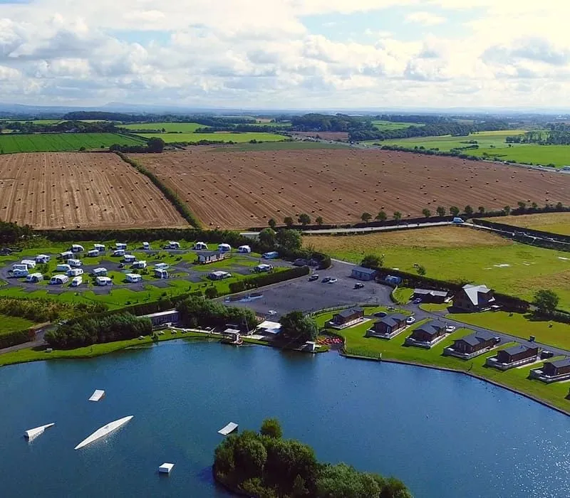 Birdseye view of the lakeside lodges surrounded by fields.