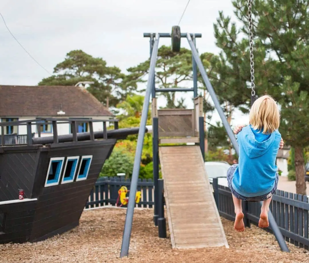Kid having fun on the zip-line in the playground at Knoll House, Dorset.