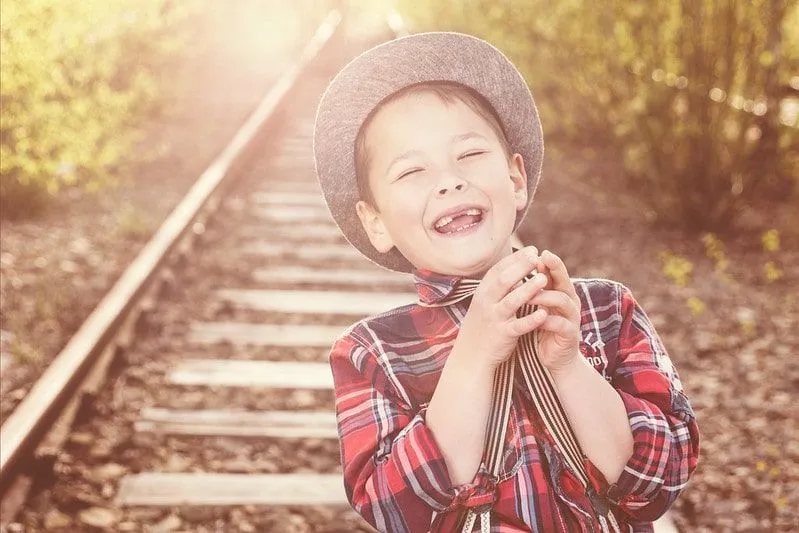 Boy laughing at a joke on a railway line.