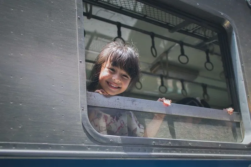 Girl smiling out the train window.