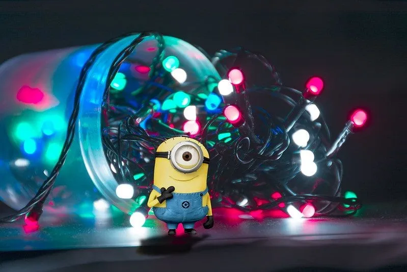 Minion standing in front of a jar with fairy lights spilling out of it.