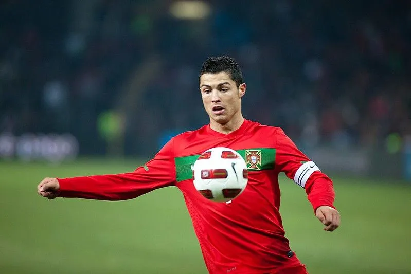 Cristiano Ronaldo kicking a football in the middle of a game.