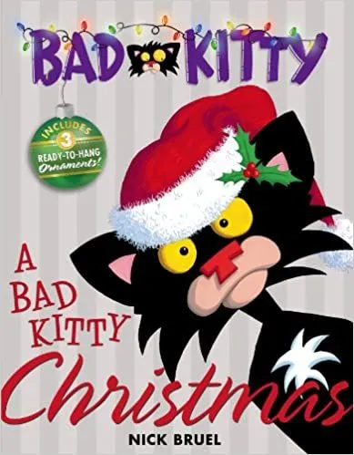 Cover of Bad Kitty: A black cat with yellow eyes is wearing a Christmas hat and is set against a pale background, looking at the viewer.