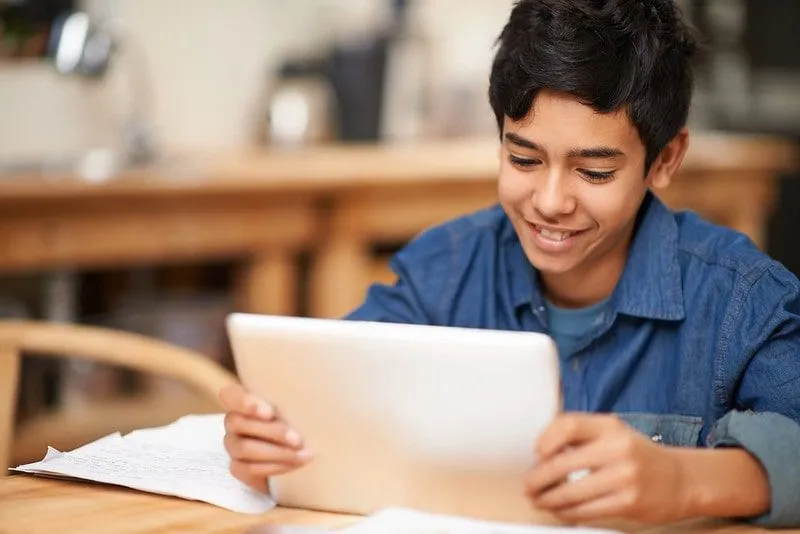 Young boy using a tablet to study a Viking timeline.