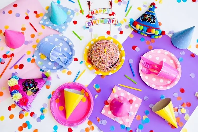Birthday cake with sprinkles and colourful party decorations.