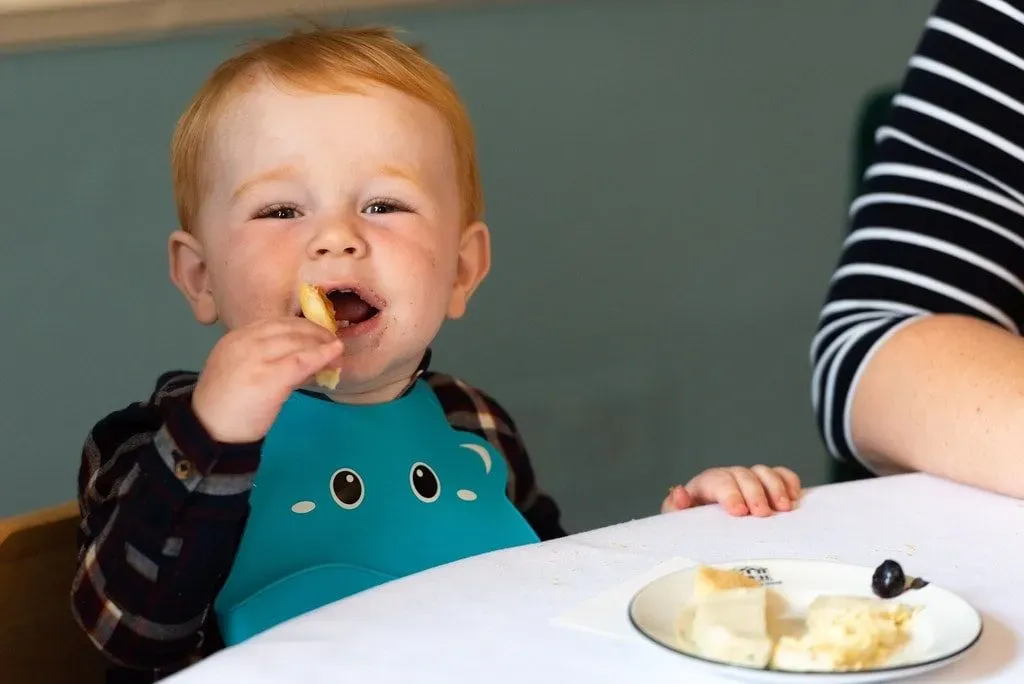 Young child enjoying food at a family-friendly afternoon tea.