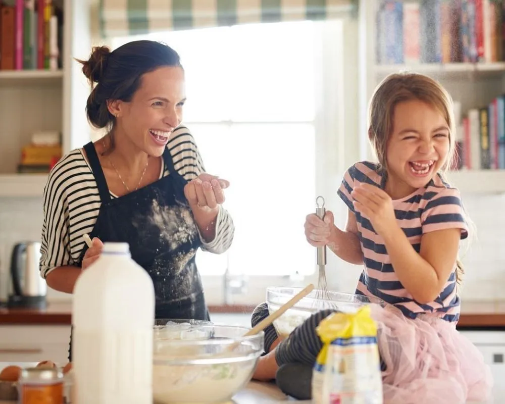 A mother and daughter baking a flourless cake together.