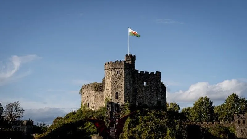 Stone keep castle in Wales with the Welsh flag flying high.