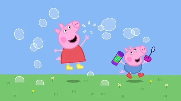 Peppa Pig and George jumping and blowing bubbles outside.