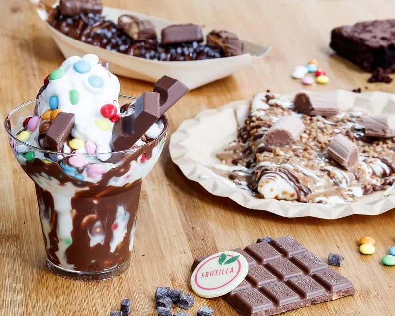 Various delicious chocolate desserts: ice cream with smarties, a crêpe with chocolate on top and a brownie.