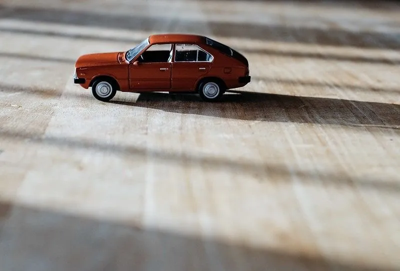 Red toy car on the wooden floor.