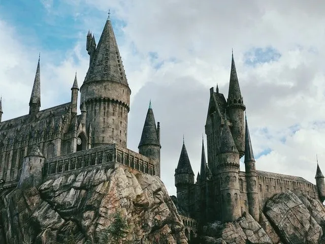 Hogwarts castle sitting high up with many turrets and its impressive style.